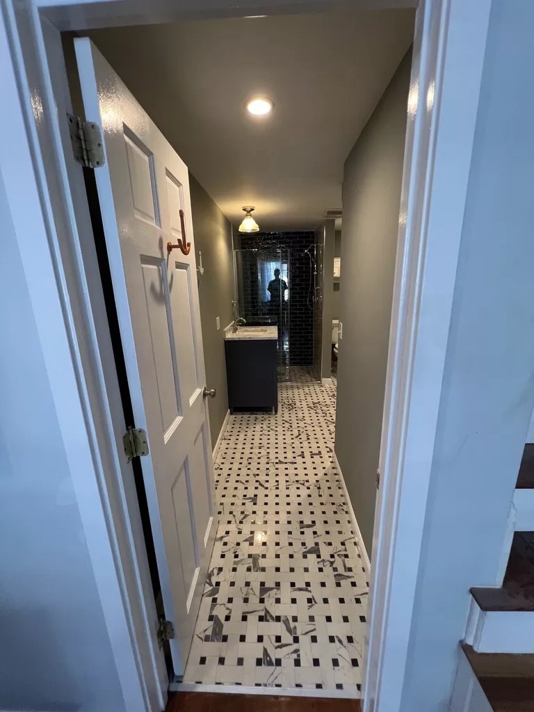 Black subway tile bath — hallway view