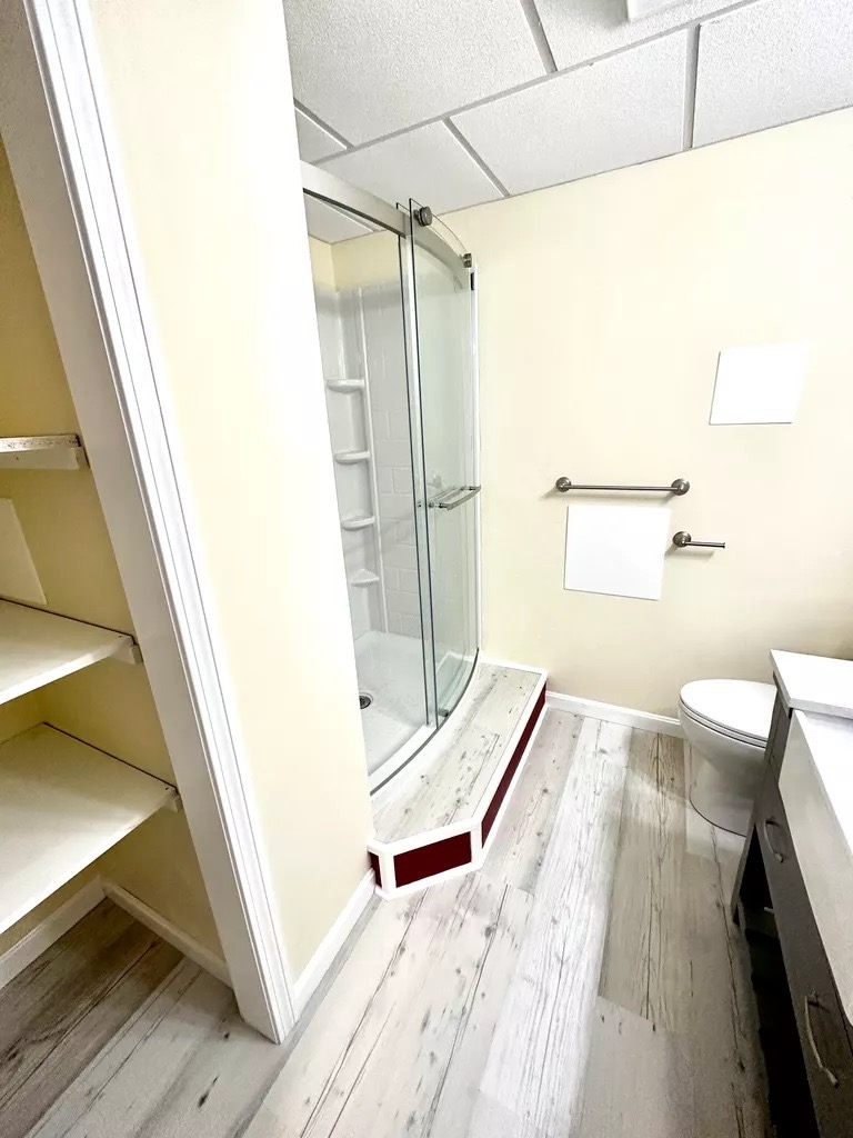 Finished bathroom — glass shower with built-in shelving