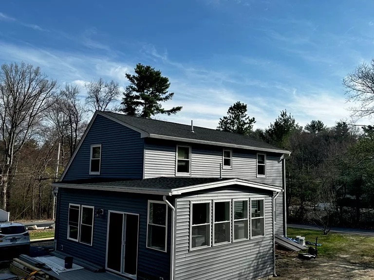 Completed exterior — new addition with blue siding